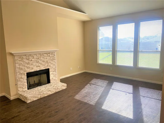 a living room with a fireplace and a floor to ceiling window