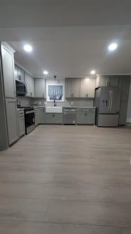 a large kitchen with kitchen island a sink stainless steel appliances and cabinets