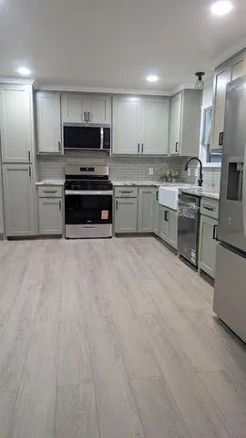 a kitchen with stainless steel appliances a refrigerator sink and cabinets