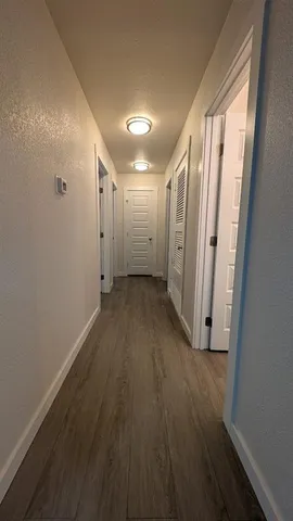 a view of a hallway with wooden floor