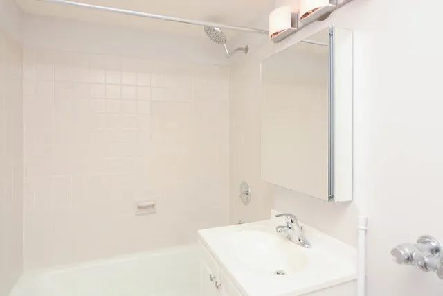 a bathroom with a white sink a shower and a mirror