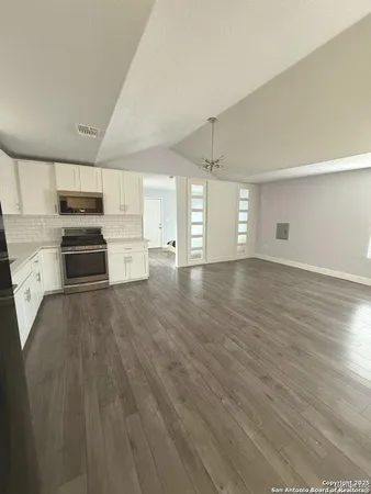 a view of empty room with wooden floor and window