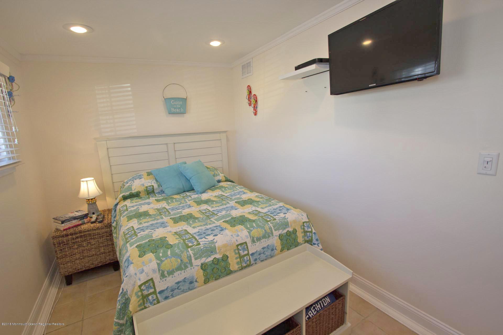 52 Fishermans Road Lavallette, NJ 08735 - Photo 24 of 74 a bedroom with a bed and a lamp