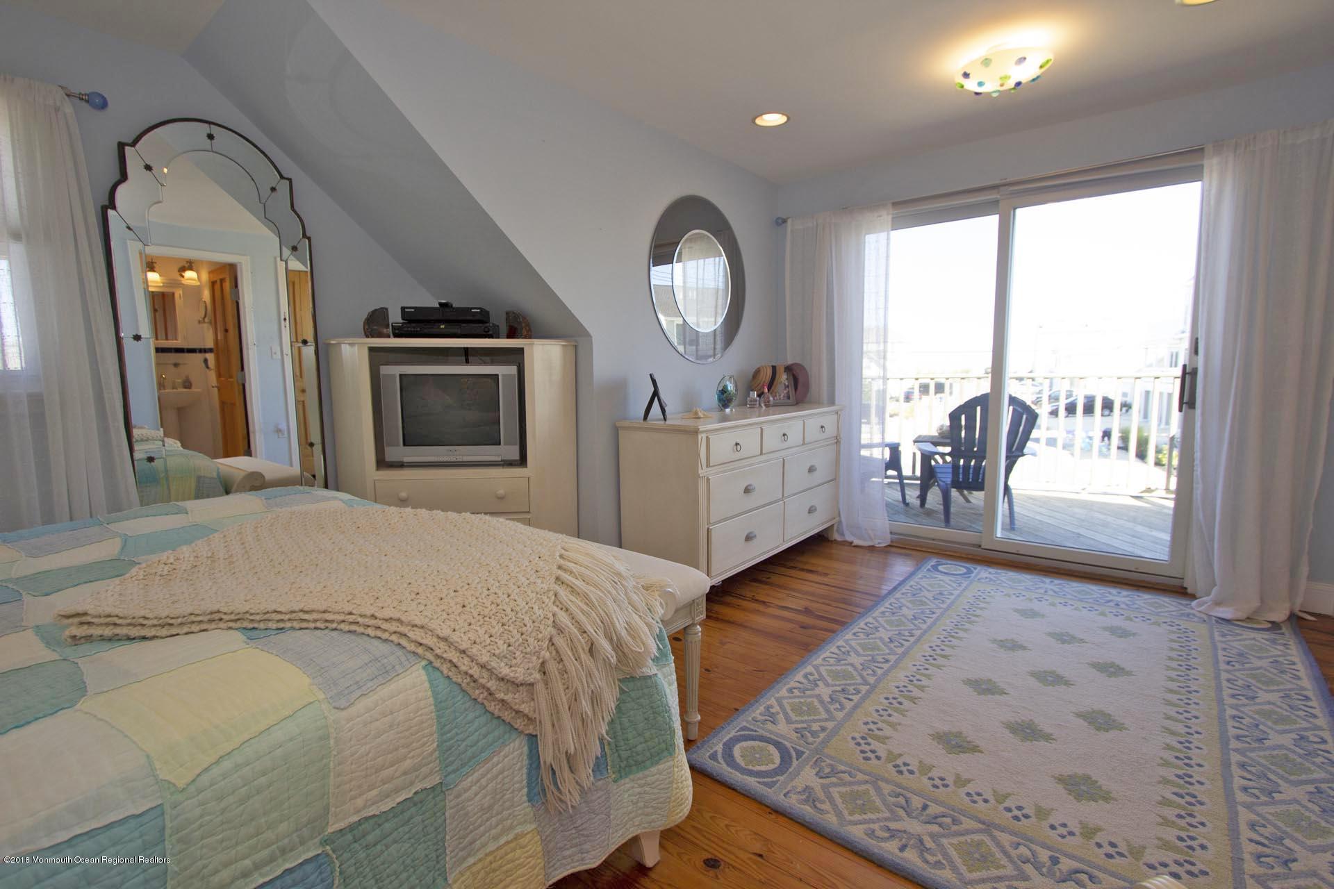 52 Fishermans Road Lavallette, NJ 08735 - Photo 46 of 74 a bedroom with a bed a mirror on dresser and a large window