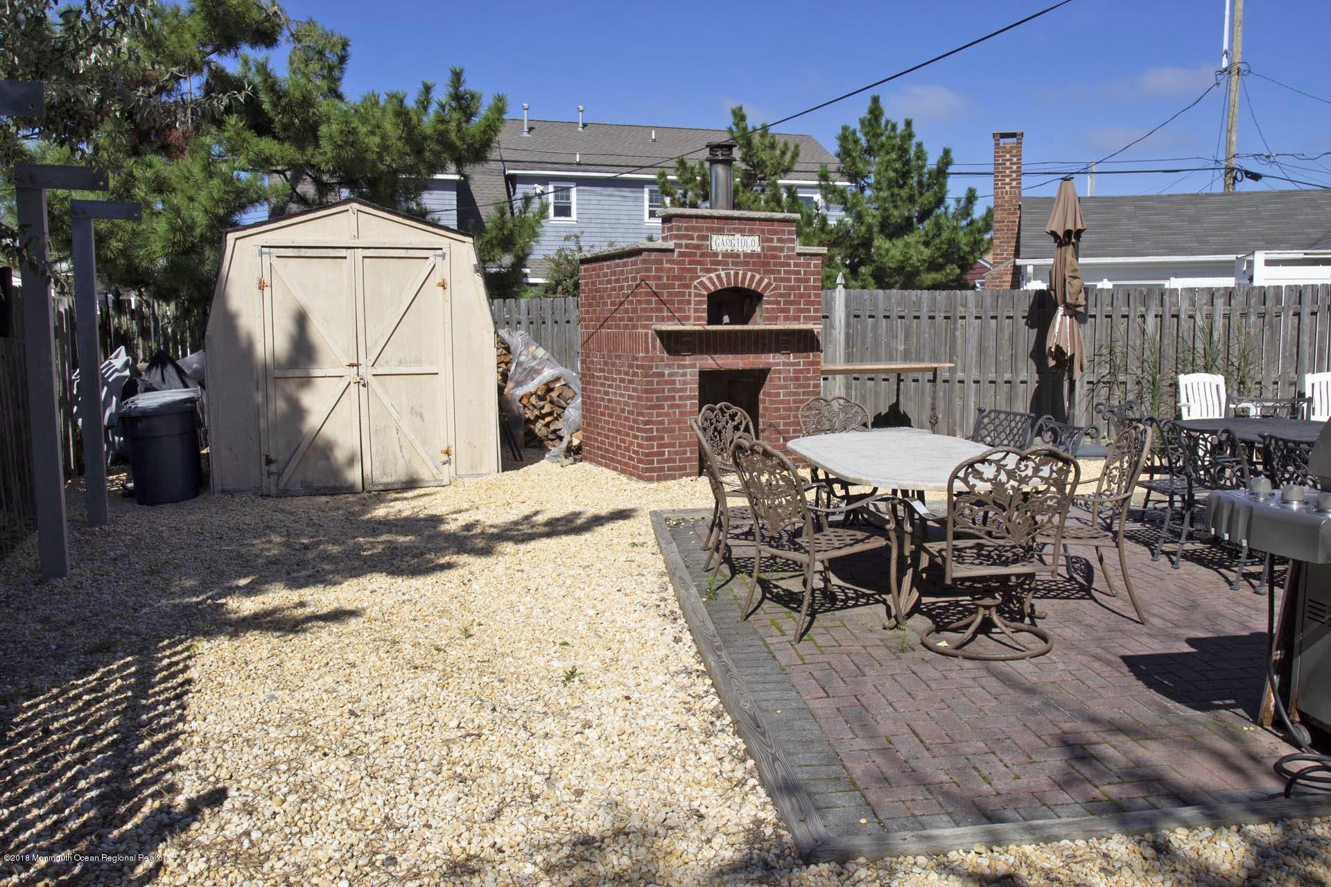 52 Fishermans Road Lavallette, NJ 08735 - Photo 62 of 74 a view of a patio with table and chairs a barbeque with wooden fence