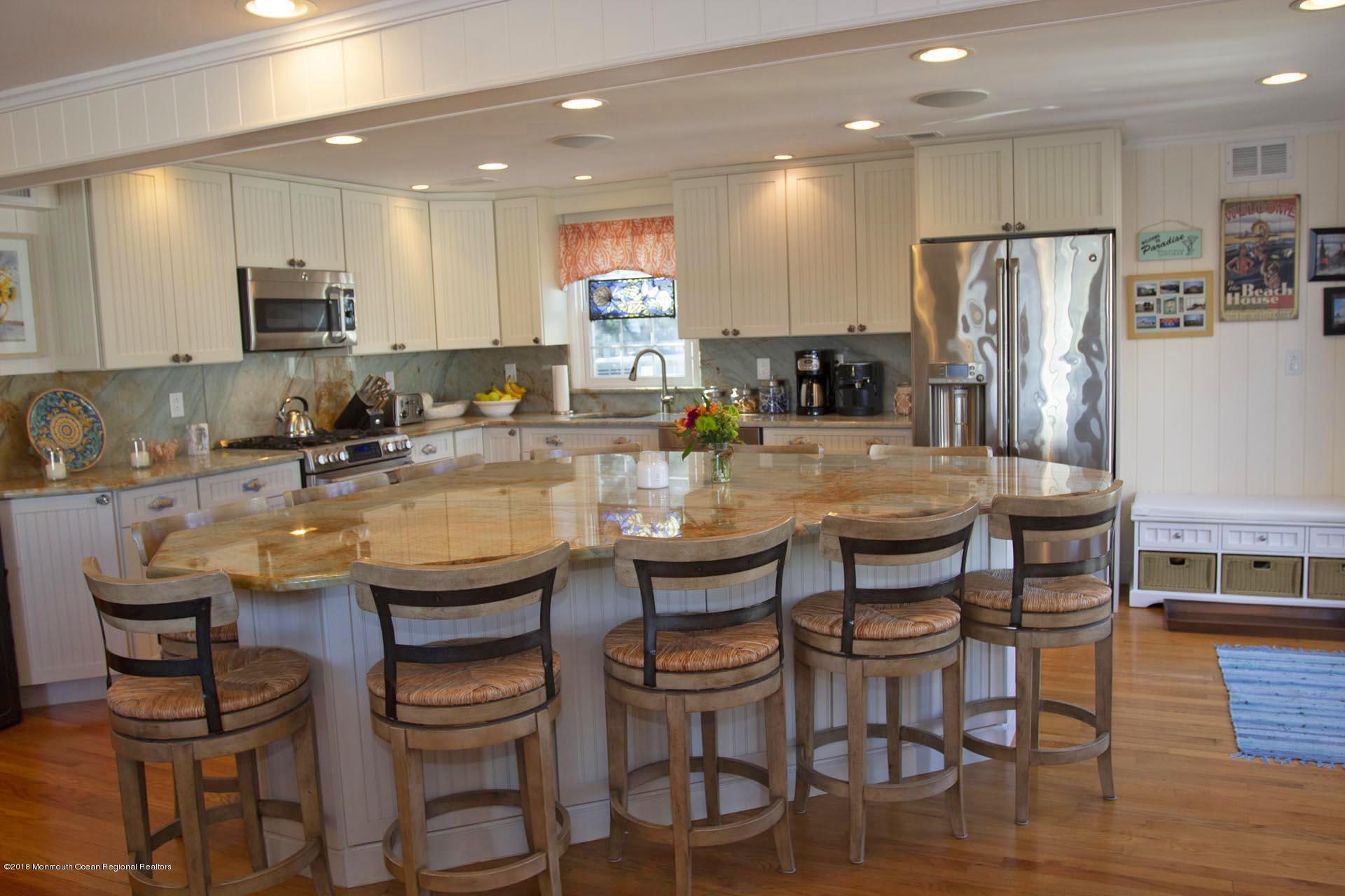 52 Fishermans Road Lavallette, NJ 08735 - Photo 9 of 74 a kitchen with granite countertop a dining table chairs refrigerator and microwave