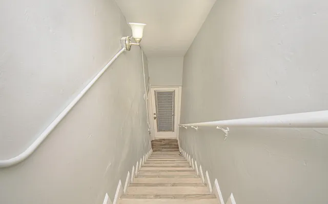 a view of a hallway with wooden floor and staircase