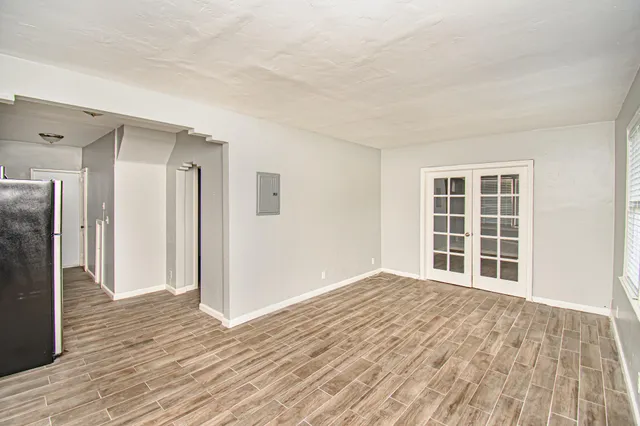 a view of empty room with wooden floor and window