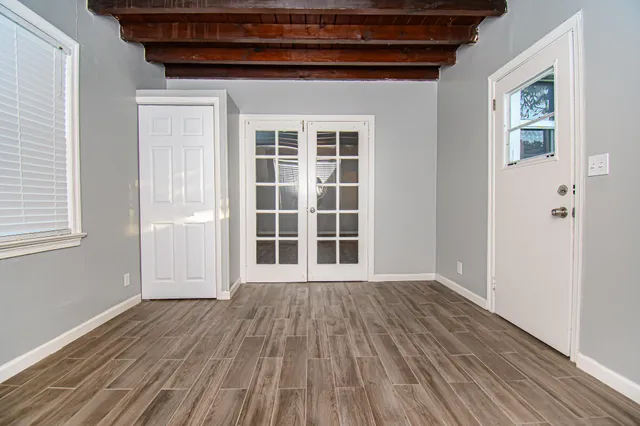 an empty room with wooden floor and windows