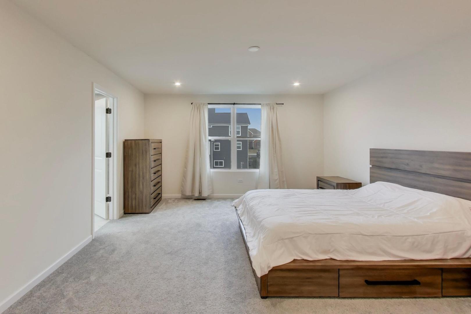 3744 Peregrine Way Elgin, IL 60124 - Photo 16 of 33 a bedroom with a bed and cabinets