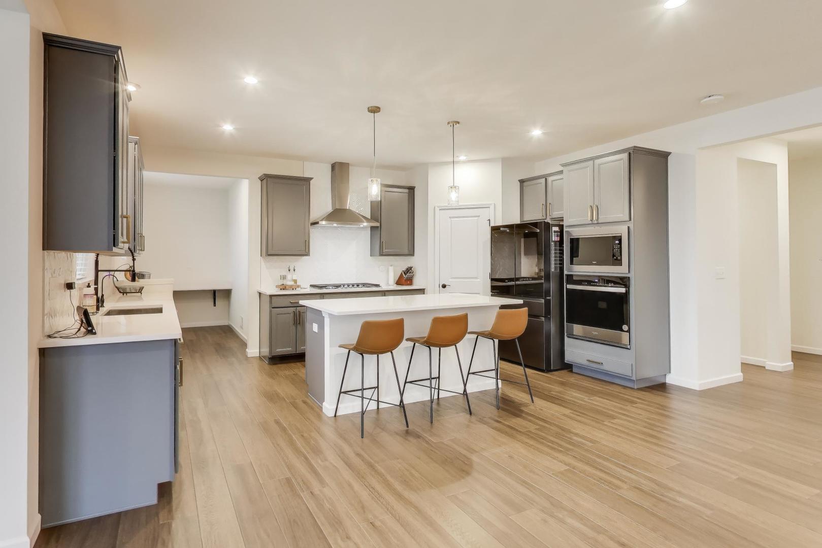 3744 Peregrine Way Elgin, IL 60124 - Photo 4 of 33 a kitchen with stainless steel appliances kitchen island granite countertop a refrigerator and a stove top oven