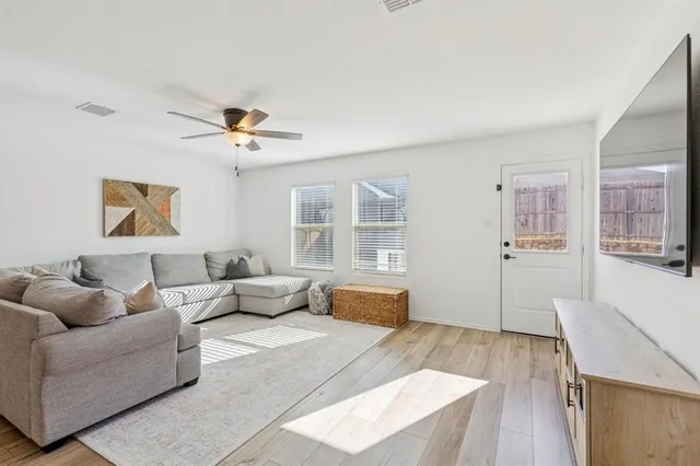 a living room with furniture and a wooden floor