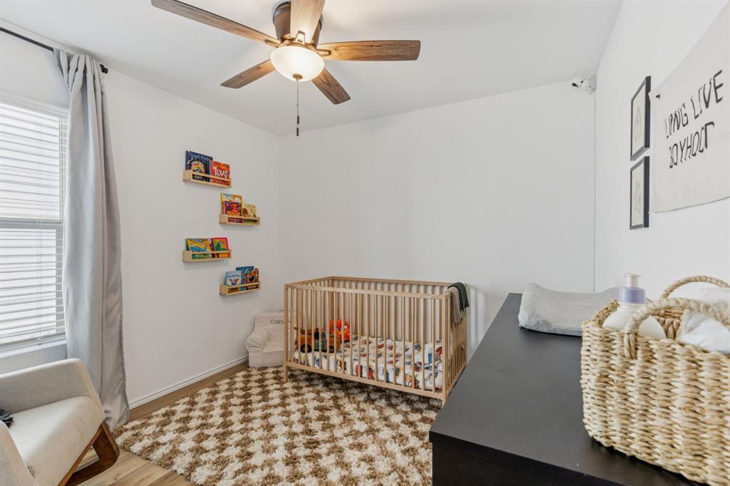 437 Frio Pass Trail Fort Worth, TX 76052 - Photo 18 of 28 a bedroom with a bed and wooden floor