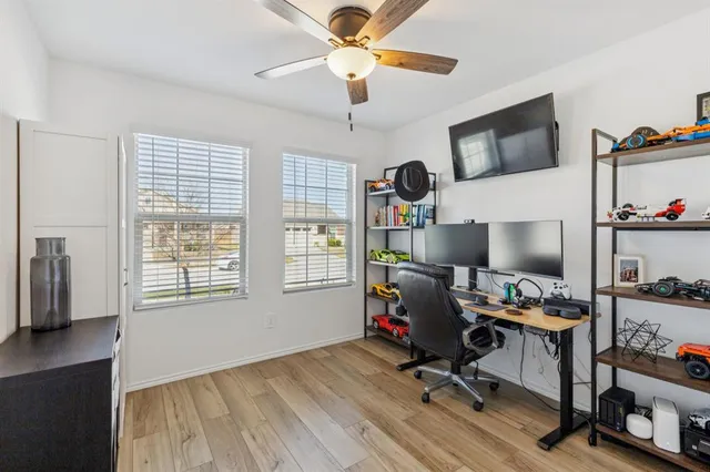 a view of a workspace with furniture and a window