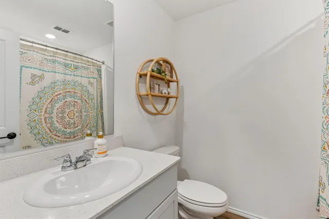 a bathroom with a toilet a sink and a mirror