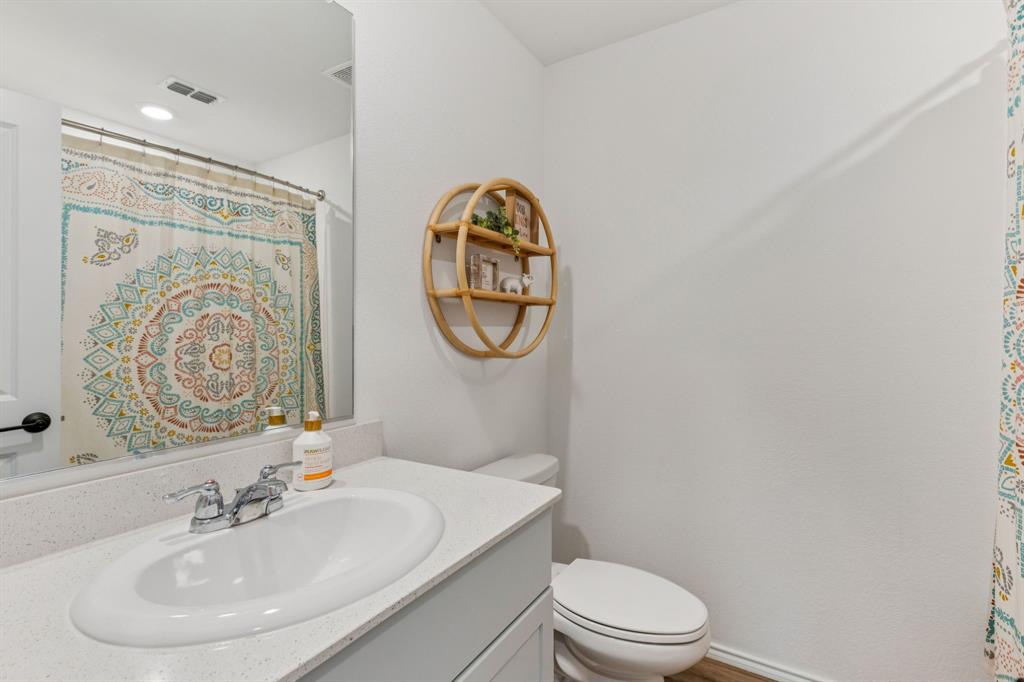 437 Frio Pass Trail Fort Worth, TX 76052 - Photo 20 of 28 a bathroom with a toilet a sink and a mirror