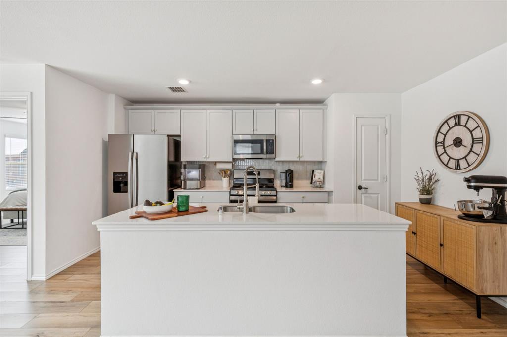 437 Frio Pass Trail Fort Worth, TX 76052 - Photo 10 of 28 a view of kitchen with stainless steel appliances granite countertop a sink a stove a refrigerator with a dining table and chairs