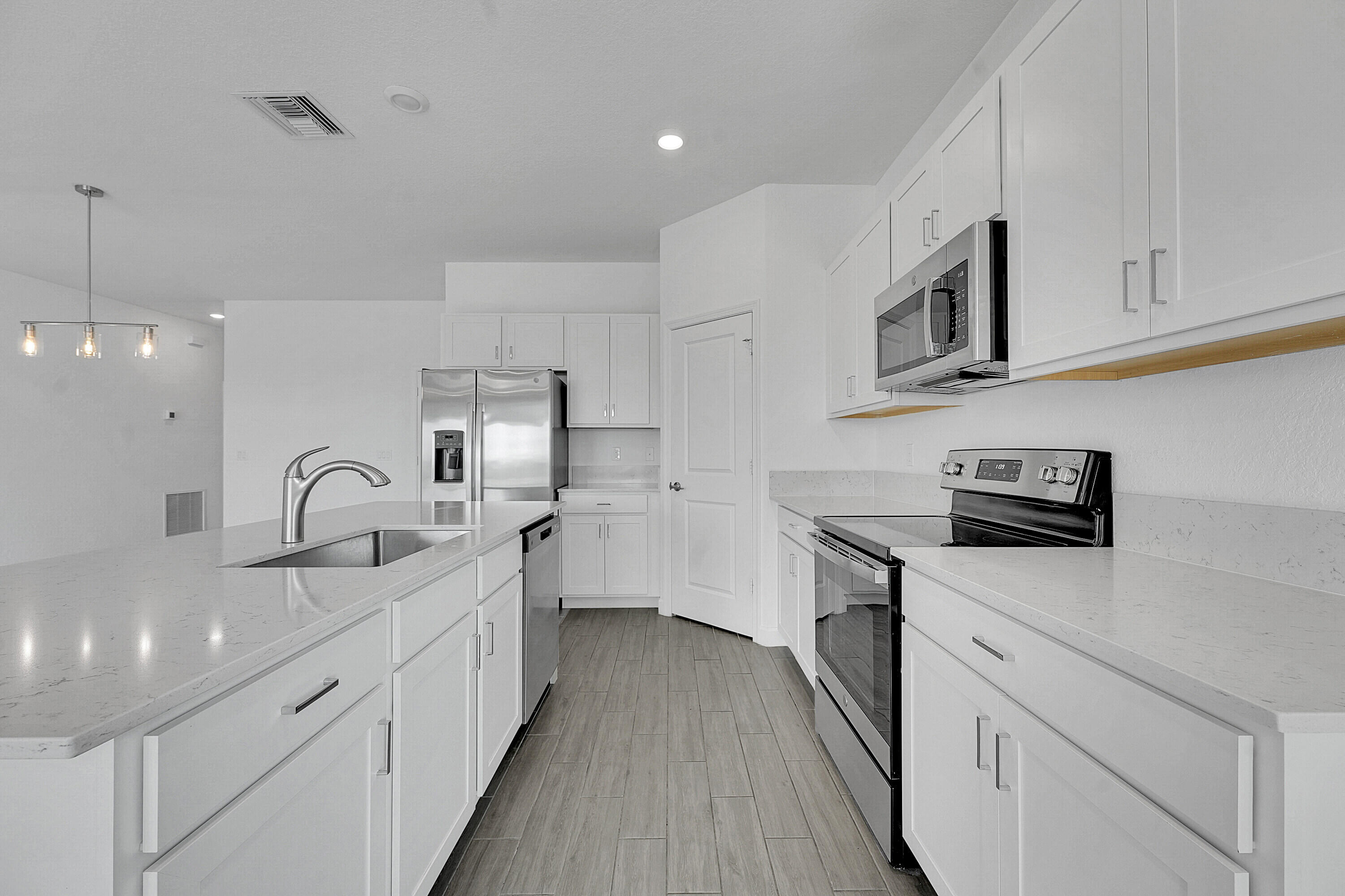 13096 Northwest Copper Creek Drive Port St. Lucie, FL 34987 - Photo 11 of 64 a kitchen with granite countertop a sink stainless steel appliances and white cabinets