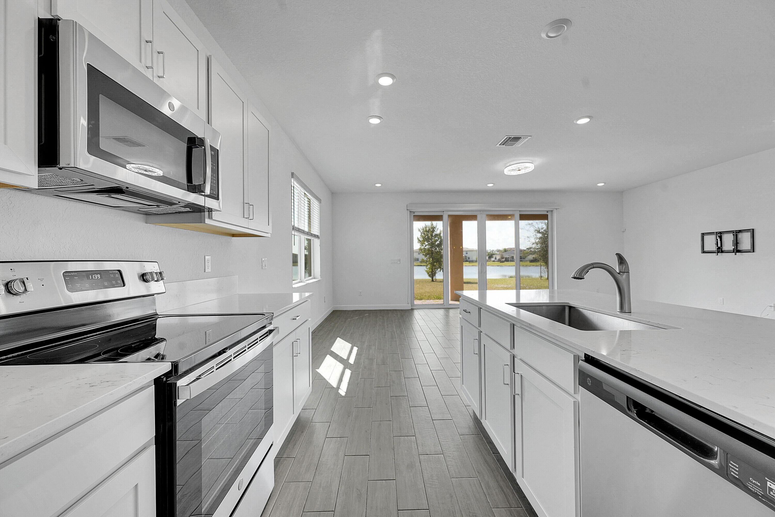 13096 Northwest Copper Creek Drive Port St. Lucie, FL 34987 - Photo 12 of 64 a kitchen with stainless steel appliances granite countertop a sink and stove top oven with wooden floor