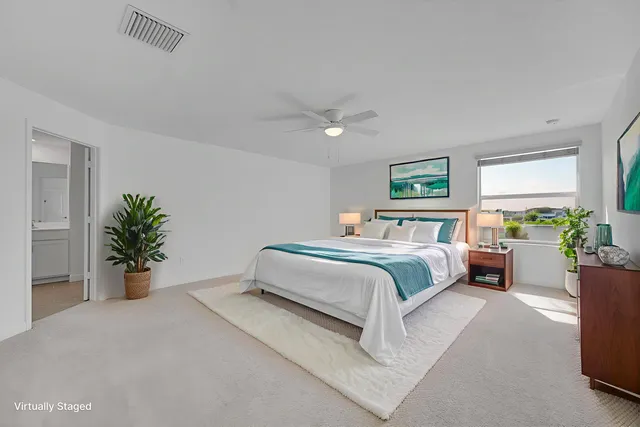 an empty room with windows and ceiling fan