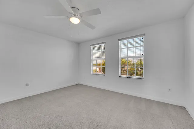 an empty room with a ceiling fan and a fan