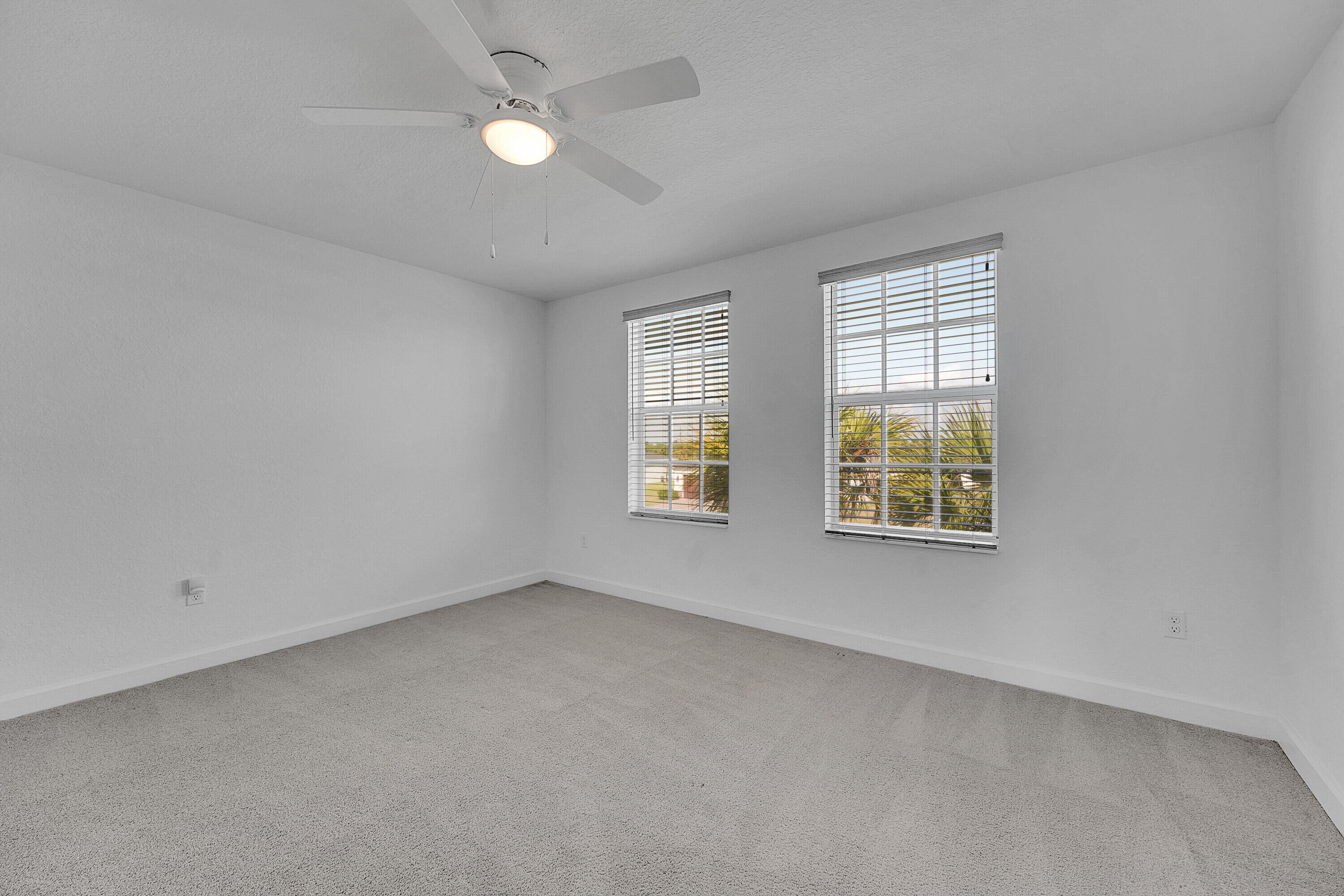 13096 Northwest Copper Creek Drive Port St. Lucie, FL 34987 - Photo 26 of 64 an empty room with windows and ceiling fan