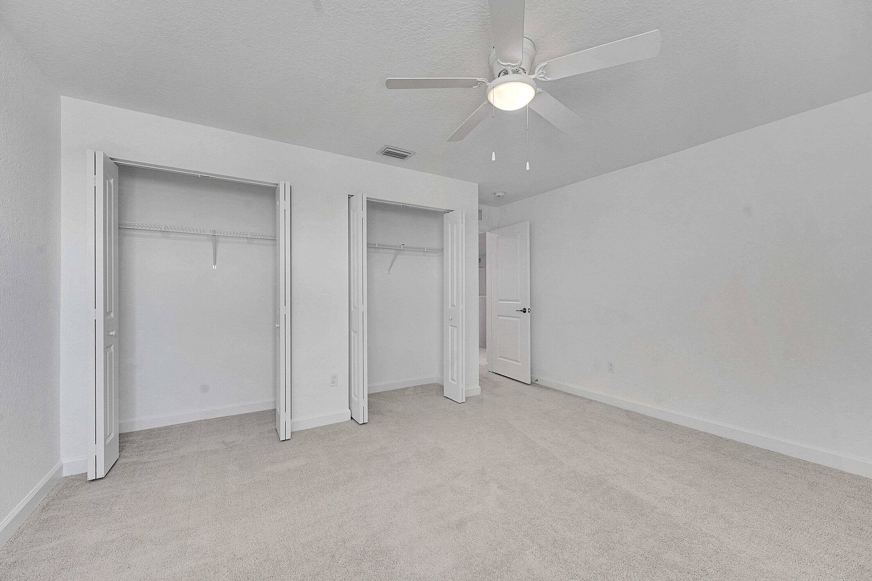 13096 Northwest Copper Creek Drive Port St. Lucie, FL 34987 - Photo 29 of 64 an empty room with a ceiling fan and a fan