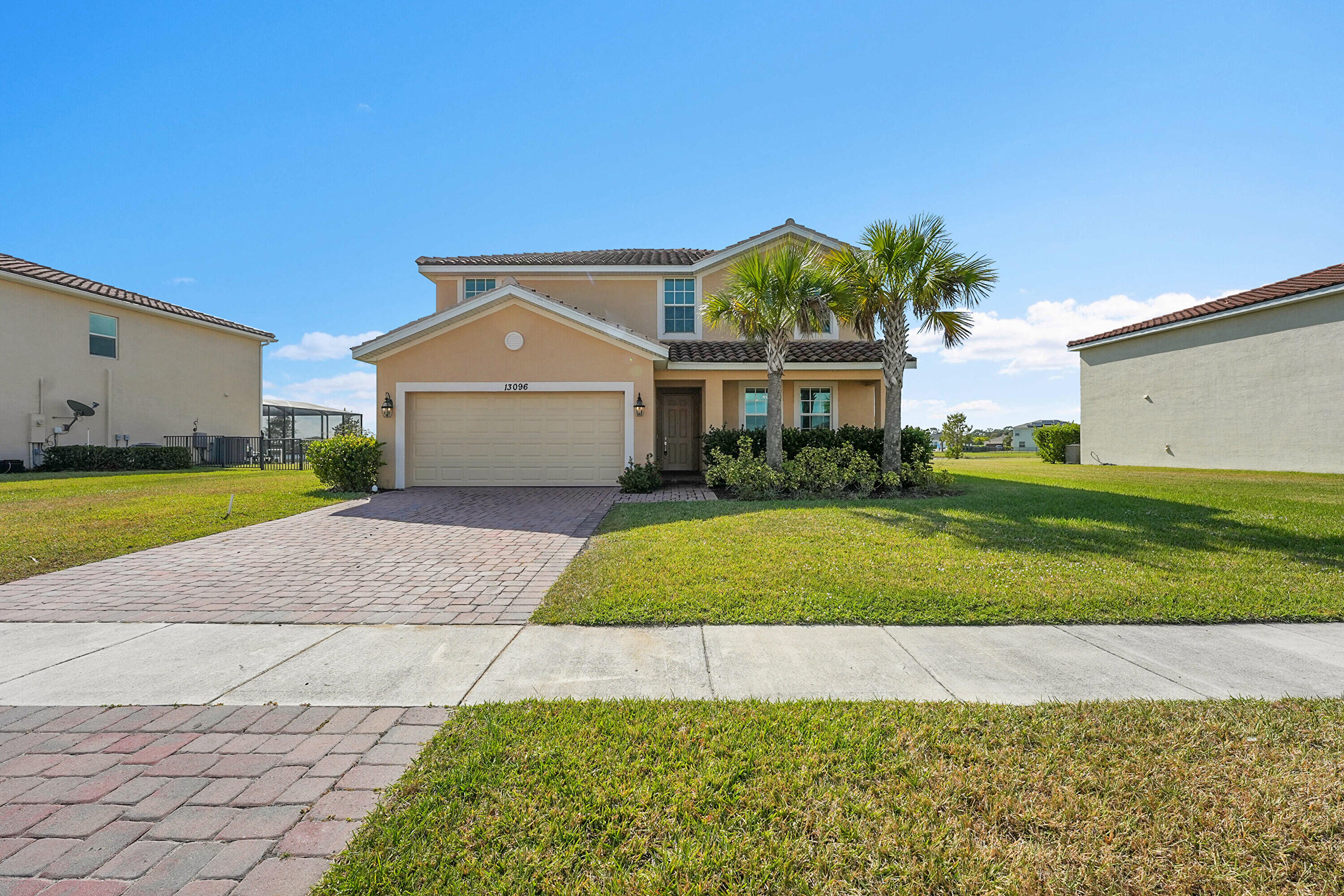 13096 Northwest Copper Creek Drive Port St. Lucie, FL 34987 - Photo 3 of 64 a front view of a house with a yard and garage