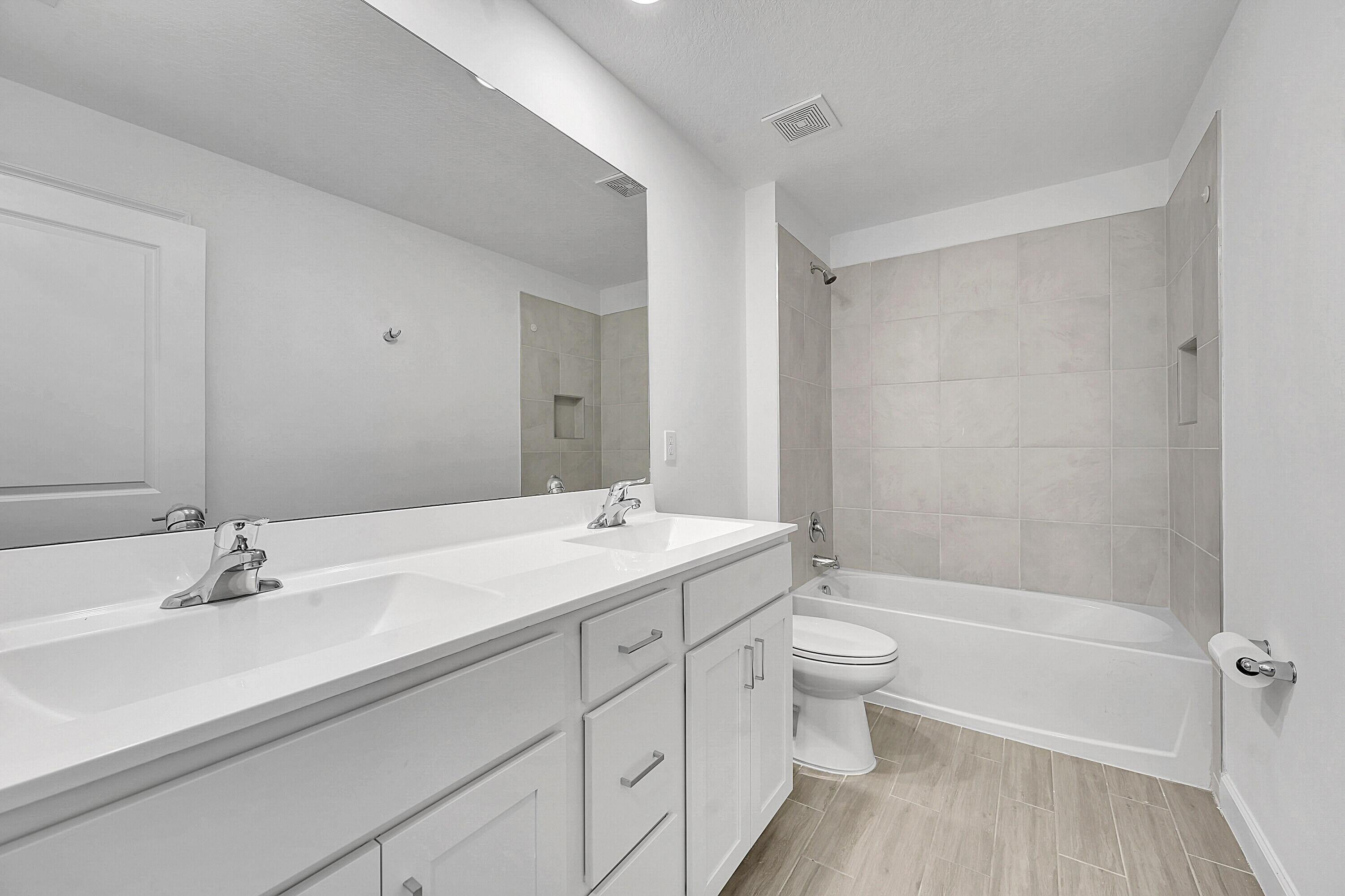 13096 Northwest Copper Creek Drive Port St. Lucie, FL 34987 - Photo 32 of 64 a bathroom with a double vanity sink toilet mirror and shower