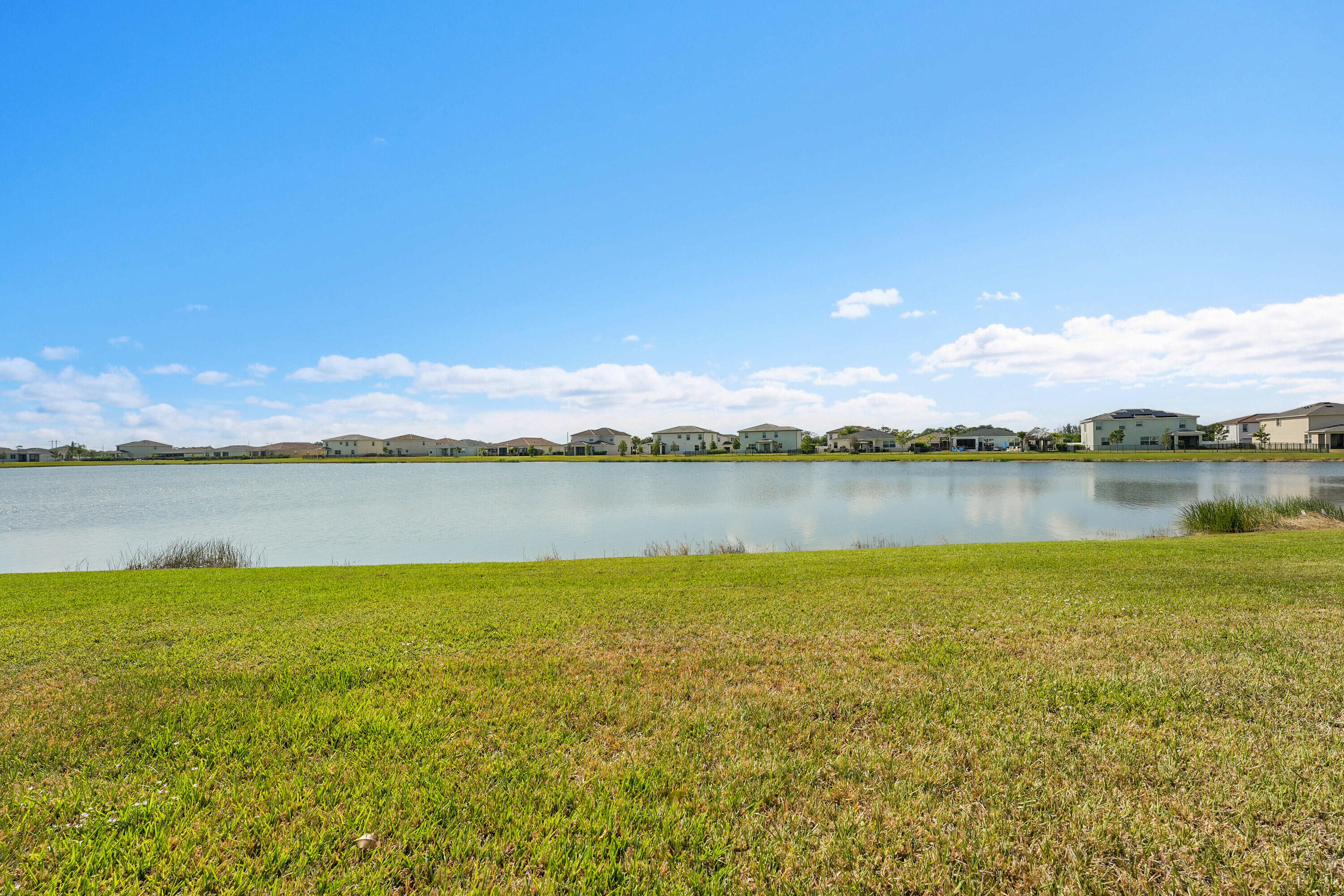 13096 Northwest Copper Creek Drive Port St. Lucie, FL 34987 - Photo 38 of 64 a view of a lake with houses in the back