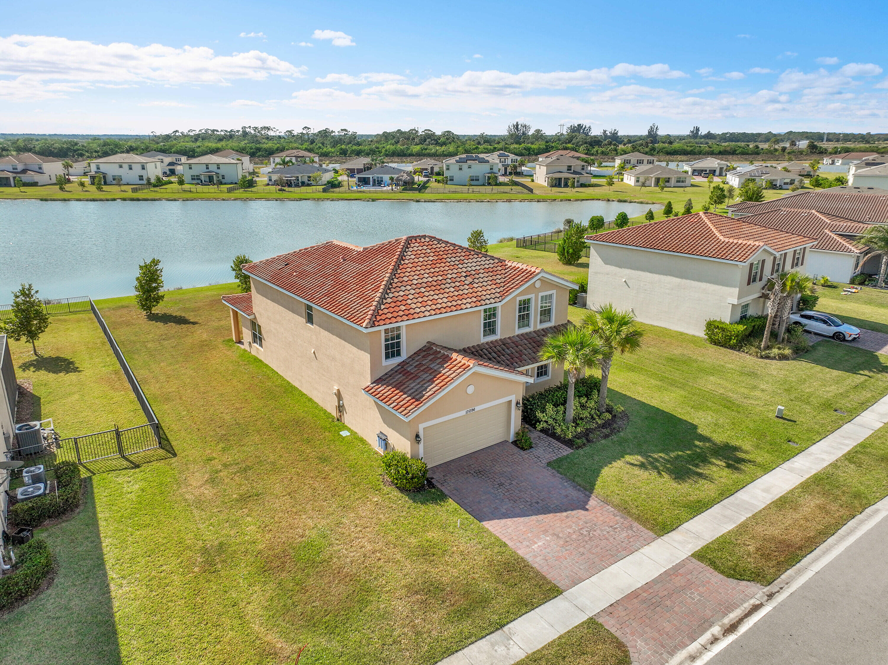 13096 Northwest Copper Creek Drive Port St. Lucie, FL 34987 - Photo 48 of 64 an aerial view of a house with pool and a lake view