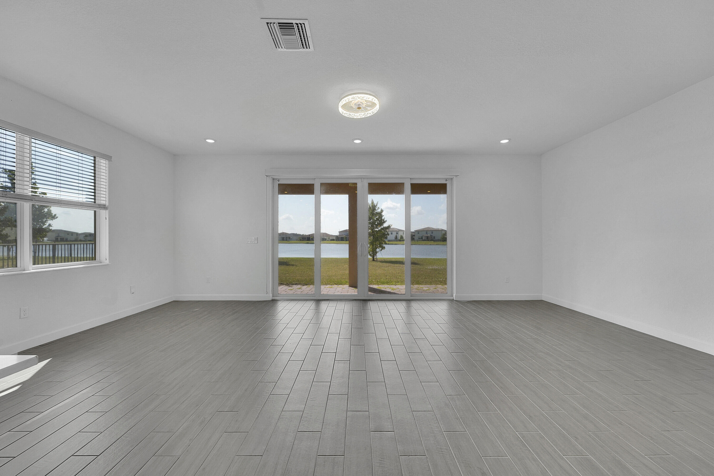 13096 Northwest Copper Creek Drive Port St. Lucie, FL 34987 - Photo 7 of 64 an empty room with wooden floor and windows