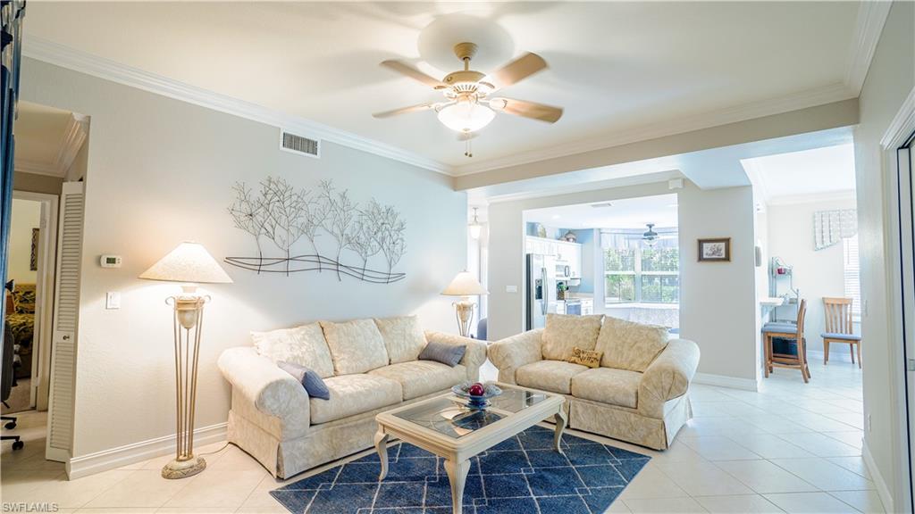 300 Diamond Circle, Unit 301 Naples, FL 34110 - Photo 16 of 43 a living room with furniture a large window and a chandelier