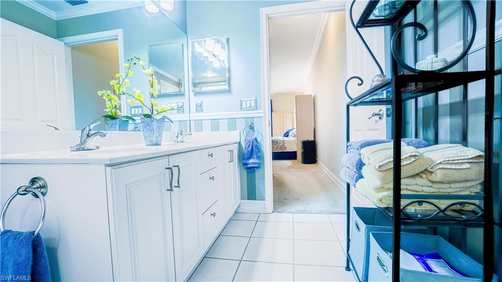 300 Diamond Circle, Unit 301 Naples, FL 34110 - Photo 25 of 43 a en suite bathroom with a double vanity sink and a mirror