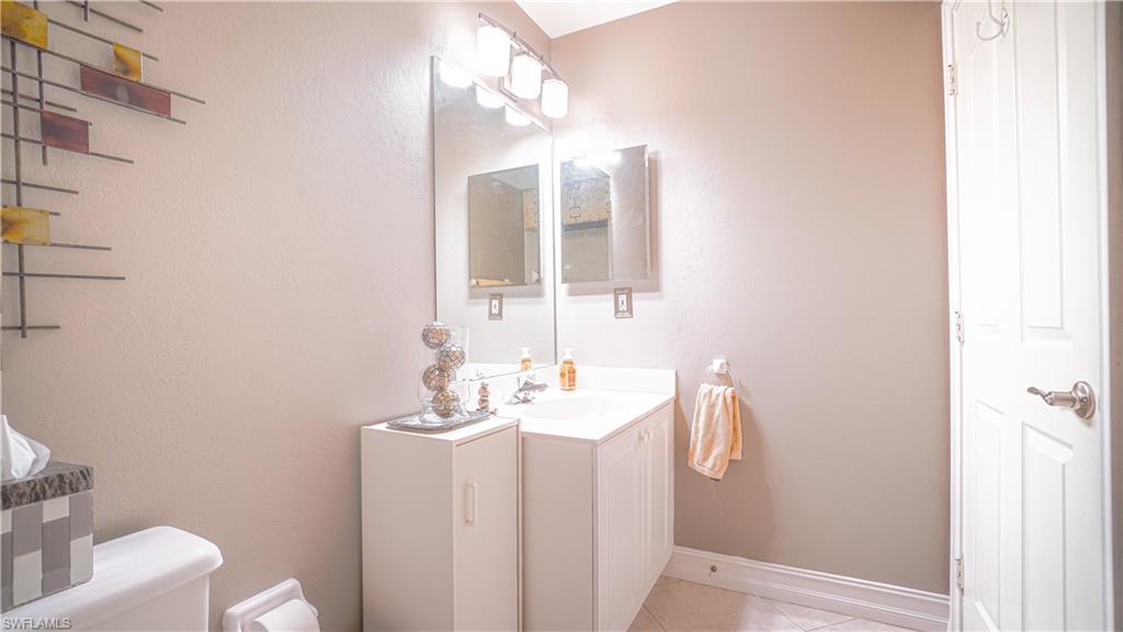 300 Diamond Circle, Unit 301 Naples, FL 34110 - Photo 28 of 43 a bathroom with a sink vanity mirror and toilet
