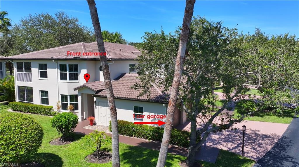 300 Diamond Circle, Unit 301 Naples, FL 34110 - Photo 3 of 43 a front view of a house with a garden