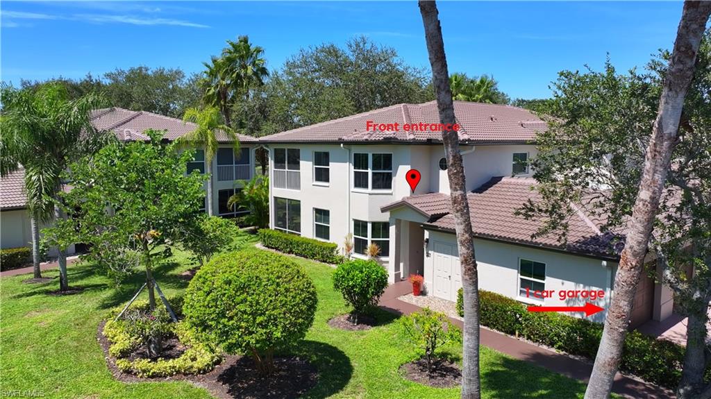 300 Diamond Circle, Unit 301 Naples, FL 34110 - Photo 42 of 43 a front view of a house with a yard and outdoor seating
