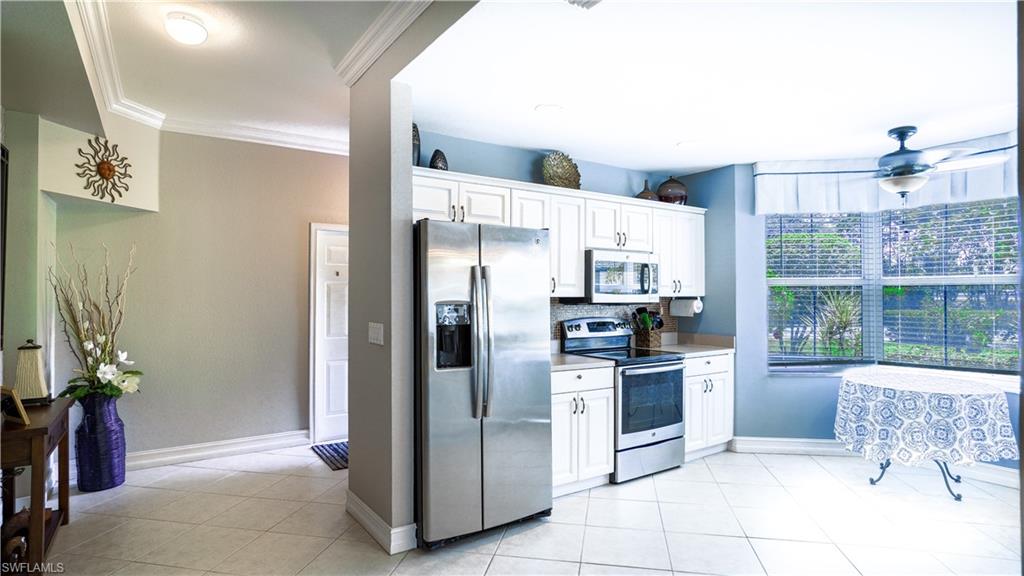 300 Diamond Circle, Unit 301 Naples, FL 34110 - Photo 5 of 43 a kitchen with stainless steel appliances a refrigerator and a stove top oven