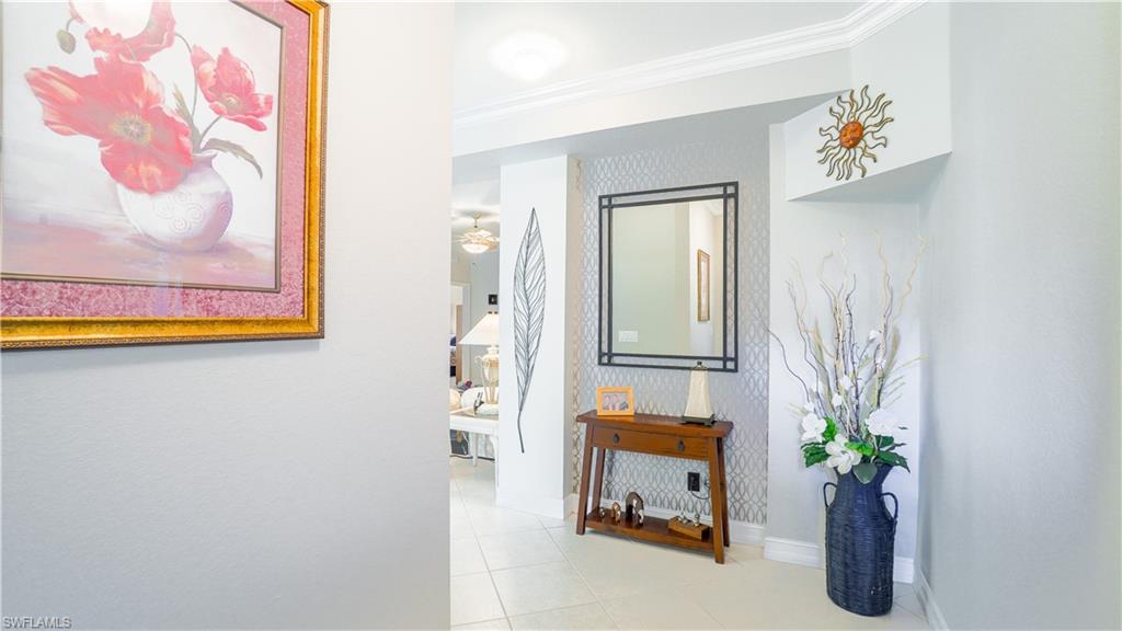 300 Diamond Circle, Unit 301 Naples, FL 34110 - Photo 6 of 43 a view of a hallway with paintings on the wall