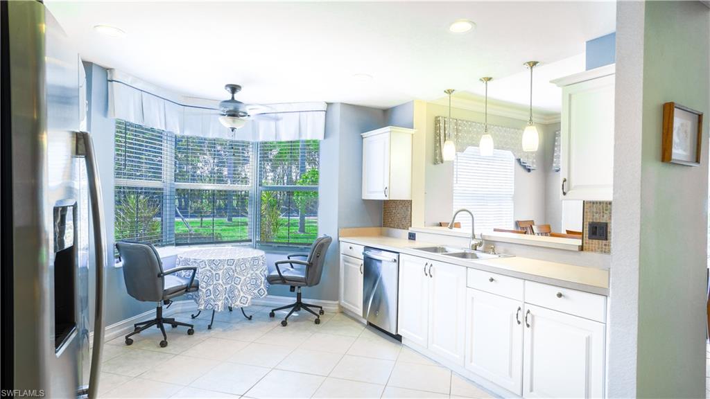300 Diamond Circle, Unit 301 Naples, FL 34110 - Photo 7 of 43 a kitchen with a sink window and chairs
