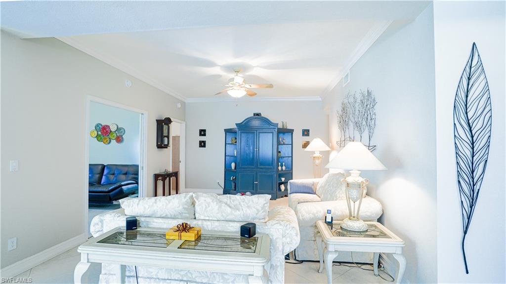 300 Diamond Circle, Unit 301 Naples, FL 34110 - Photo 9 of 43 a living room with furniture and a chandelier