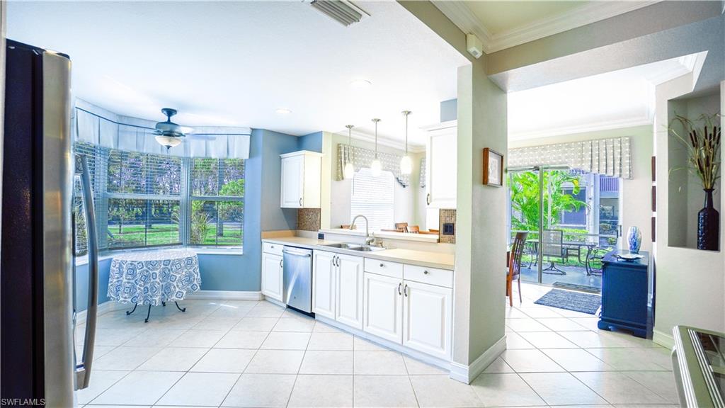 300 Diamond Circle, Unit 301 Naples, FL 34110 - Photo 10 of 43 a large white kitchen with a large window and cabinets