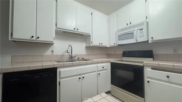 a kitchen with white cabinets and white appliances