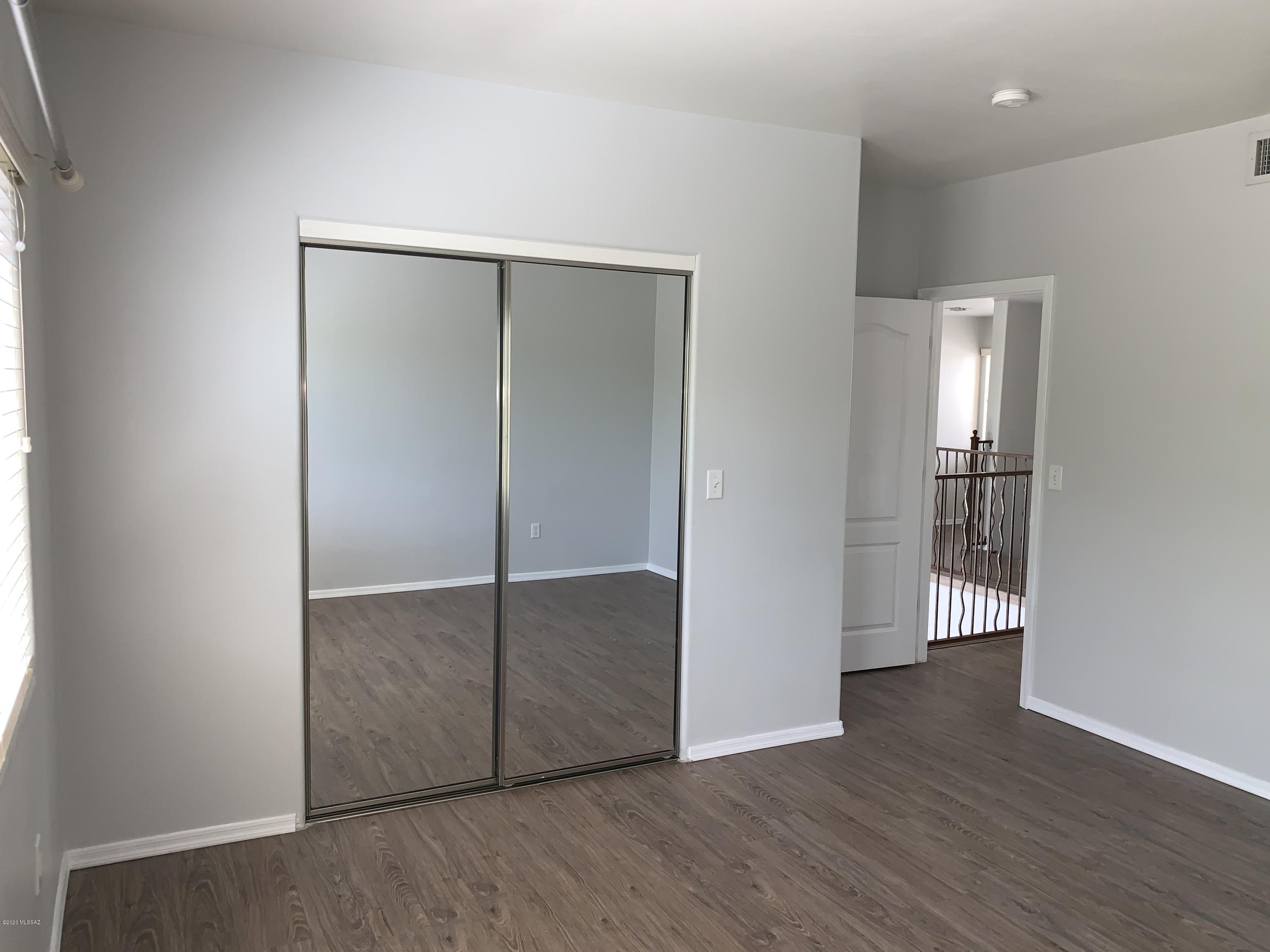 4181 North Fortune Loop Tucson, AZ 85719 - Photo 29 of 39 an empty room with wooden floor and windows