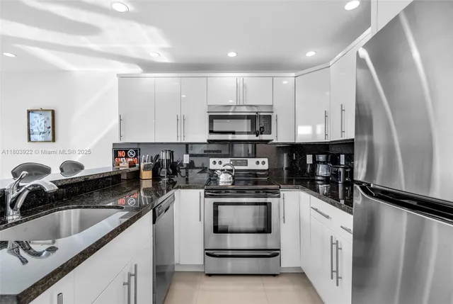 a kitchen with white cabinets sink and stainless steel appliances