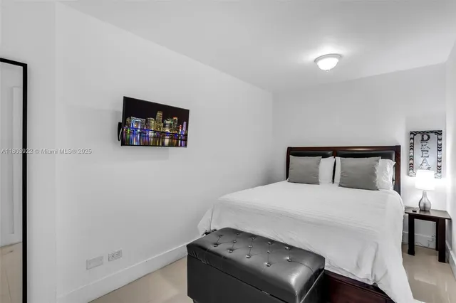 a bedroom with a bed and a tv on table