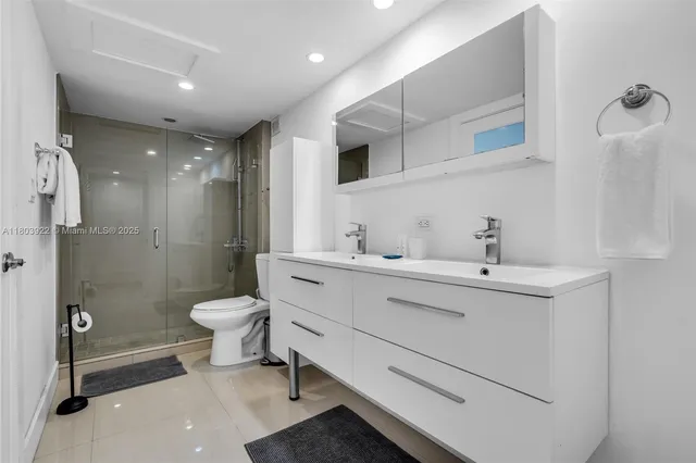 a bathroom with a toilet sink a mirror and shower