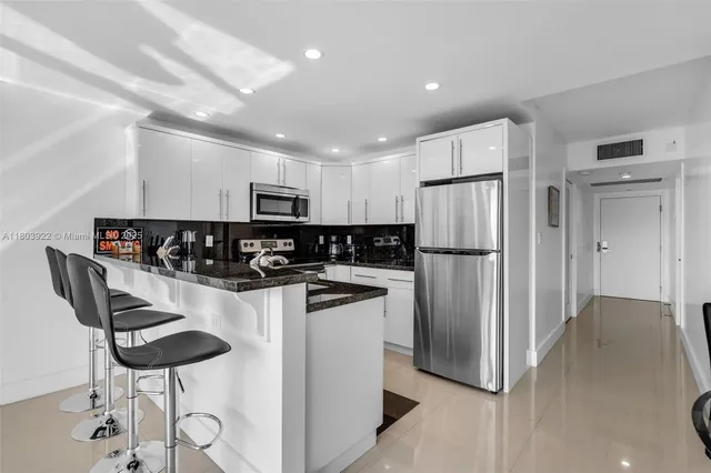 a kitchen with stainless steel appliances granite countertop a refrigerator and a stove top oven