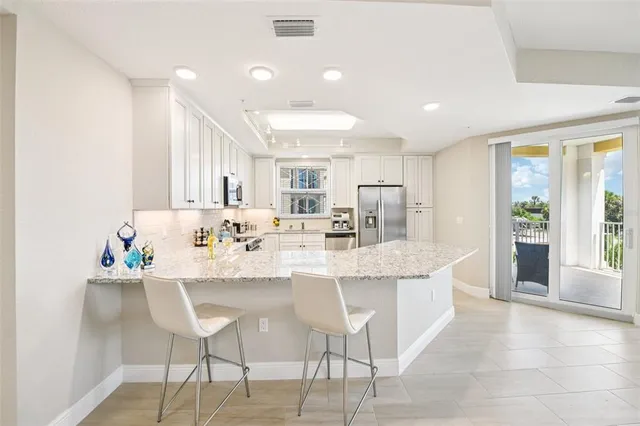 a kitchen with stainless steel appliances kitchen island granite countertop a sink and cabinets
