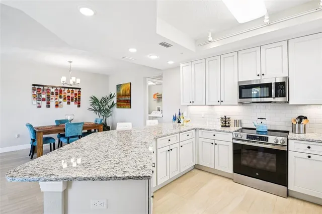 a kitchen with stainless steel appliances granite countertop a sink stove and cabinets